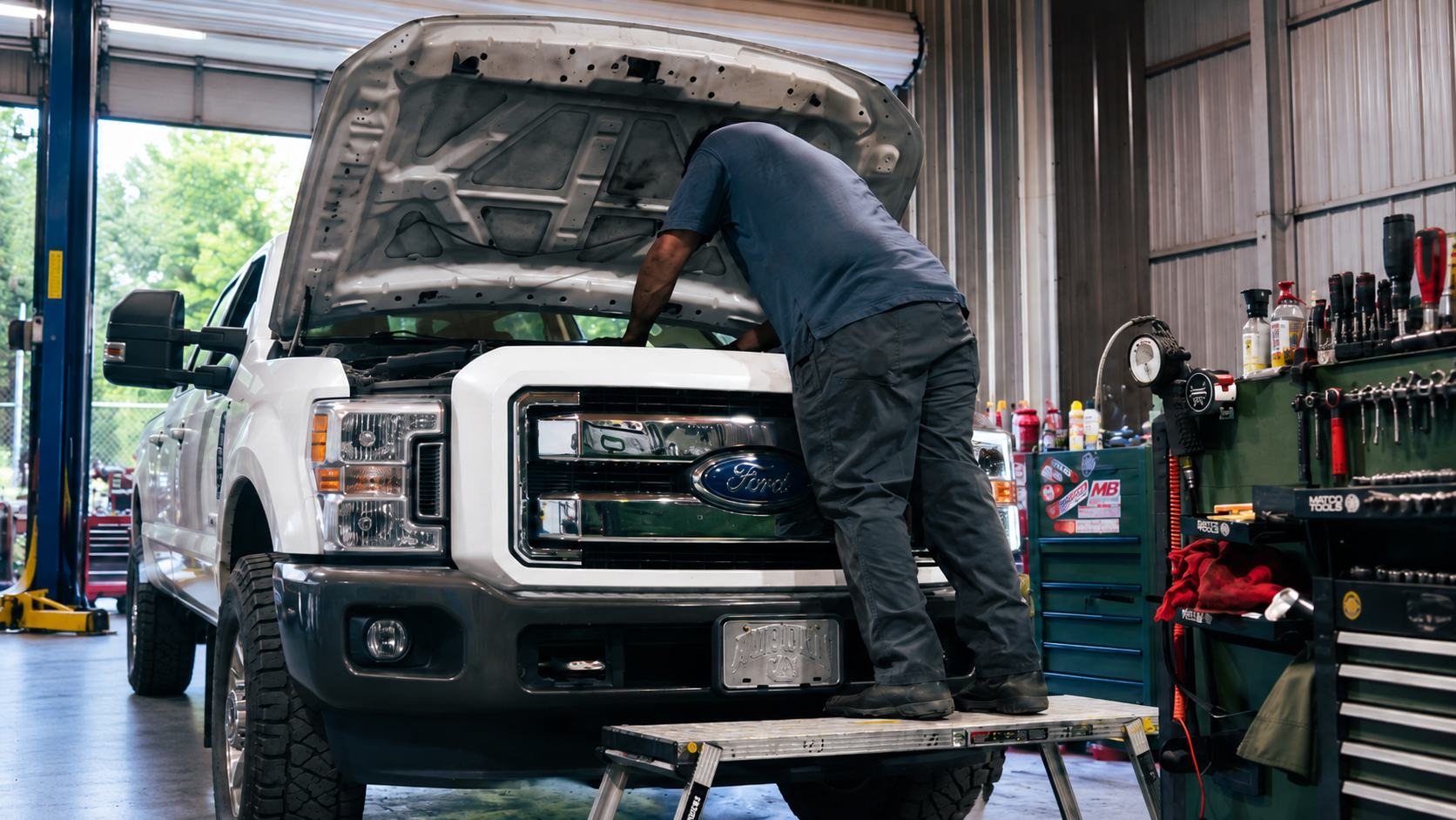 D&K technician working under the hood of a white Ford Super Duty